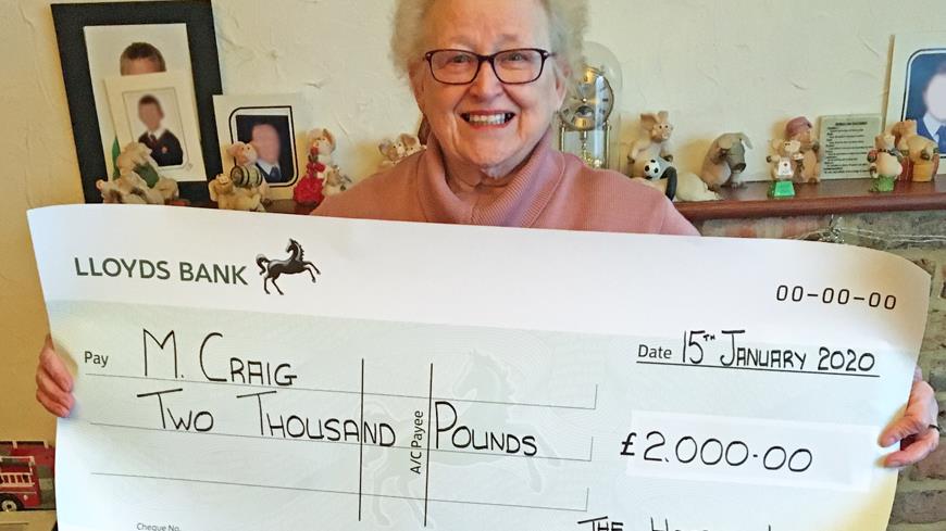 Winter Superdraw Winner receives cheque.
